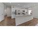 Bright kitchen with white cabinets, granite countertops, stainless steel appliances, and hardwood floors at 94 Shooting Star Ln, Clayton, NC 27520