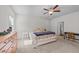 Well-lit main bedroom featuring neutral carpet, ceiling fan, natural light, and a glimpse into ensuite bath at 94 Shooting Star Ln, Clayton, NC 27520