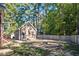 Spacious fenced backyard with a custom fire pit, detached garage, and mature trees offering privacy at 100 Bradborne Cir, Clayton, NC 27520