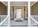 Inviting front porch with classic columns and sidelight windows framing the front door at 100 Bradborne Cir, Clayton, NC 27520