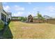 Spacious, fenced backyard features a large play set and plenty of grassy area for recreational activities at 104 Lingonberry Dr, Holly Springs, NC 27540