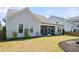 Landscaped backyard with well-manicured lawn leading to the screened-in patio, surrounded by verdant greenery at 104 Lingonberry Dr, Holly Springs, NC 27540