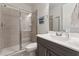 Modern bathroom with glass shower door, vanity sink, and well-lit mirror at 104 Lingonberry Dr, Holly Springs, NC 27540