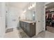 Bathroom featuring double sinks, a granite countertop, and access to the walk-in closet at 104 Lingonberry Dr, Holly Springs, NC 27540