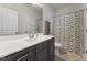Bathroom features a gray vanity, white countertops, shower with geometric curtain, and tiled floor at 104 Lingonberry Dr, Holly Springs, NC 27540