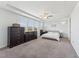 Spacious bedroom featuring a tray ceiling, ceiling fan, and large windows for ample natural light at 104 Lingonberry Dr, Holly Springs, NC 27540