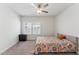 Bright bedroom with ceiling fan and colorful comforter has carpeted floor and light gray walls at 104 Lingonberry Dr, Holly Springs, NC 27540