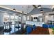 Bright clubhouse area with high ceilings, modern lighting, a kitchen, and tables near large windows at 104 Lingonberry Dr, Holly Springs, NC 27540