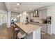 Open kitchen with an expansive island, granite countertops, stainless steel appliances and pendant lights at 104 Lingonberry Dr, Holly Springs, NC 27540