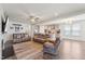 Open-concept living room flowing into the kitchen with a fireplace, ceiling fan and wood floors at 104 Lingonberry Dr, Holly Springs, NC 27540