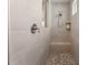 Elegant walk-in shower featuring neutral tile, a built-in bench, and a mosaic tile floor at 104 Lingonberry Dr, Holly Springs, NC 27540