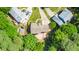 Aerial view of home featuring a deck and multiple outbuildings on a tree-lined lot at 104 Ludstone Ct, Cary, NC 27513