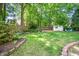 Fenced backyard with lush lawn, shed, firepit, and garden is an outdoor paradise at 104 Ludstone Ct, Cary, NC 27513