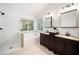 Bright bathroom featuring a tiled shower, soaking tub, and double vanity with dark wood cabinets at 104 Ludstone Ct, Cary, NC 27513