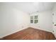 Empty bedroom with hardwood floors, large window, and neutral paint at 104 Ludstone Ct, Cary, NC 27513