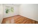 Empty bedroom with hardwood floors, large window, and neutral paint at 104 Ludstone Ct, Cary, NC 27513