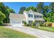 Charming two-story home boasts a manicured lawn, attached garage, and welcoming curb appeal at 104 Ludstone Ct, Cary, NC 27513