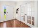 Bright entryway with wood floors, shiplap accent wall, and glass paned french doors leading to a cozy living space at 104 Ludstone Ct, Cary, NC 27513