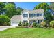 Charming two-story home with a manicured lawn and classic black shutters and a brick and shrub border at 104 Ludstone Ct, Cary, NC 27513
