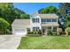 Charming two-story home with black shutters, an attached garage and a well-manicured front yard at 104 Ludstone Ct, Cary, NC 27513