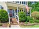 Inviting front porch with brick steps, white railings, and lush landscaping, perfect for curb appeal at 104 Ludstone Ct, Cary, NC 27513