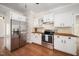 Charming kitchen featuring white cabinets, butcher block countertops, and stainless steel appliances at 104 Ludstone Ct, Cary, NC 27513