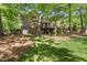 Spacious backyard featuring a large brick home, deck, covered patio, and mature trees at 10825 Rondeau Woods Ct, Raleigh, NC 27614