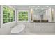 Bright bathroom showcasing a soaking tub with a view and granite countertops at 10825 Rondeau Woods Ct, Raleigh, NC 27614