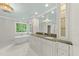 Bright bathroom featuring double sinks, a soaking tub, and custom white cabinetry at 10825 Rondeau Woods Ct, Raleigh, NC 27614