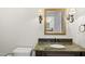 Bathroom with bronze fixtures, granite vanity, and sconces at 10825 Rondeau Woods Ct, Raleigh, NC 27614