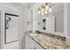Well-lit bathroom with granite countertop, decorative vanity and shower at 10825 Rondeau Woods Ct, Raleigh, NC 27614