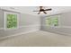 Bright, empty bedroom with two large windows and neutral carpeting at 10825 Rondeau Woods Ct, Raleigh, NC 27614