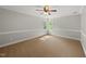 Bright bedroom with natural light, neutral paint, and carpet flooring at 10825 Rondeau Woods Ct, Raleigh, NC 27614