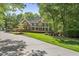Traditional brick home with mature trees, manicured landscaping and long driveway at 10825 Rondeau Woods Ct, Raleigh, NC 27614