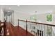 Upstairs hallway boasts hardwood floors and views of the living room fireplace at 10825 Rondeau Woods Ct, Raleigh, NC 27614