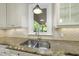 Gourmet kitchen featuring stainless steel sink, granite countertops, and backyard views at 10825 Rondeau Woods Ct, Raleigh, NC 27614