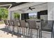 Entertain friends at your outdoor kitchen, featuring bar seating, cabinets and a large screen TV at 10825 Rondeau Woods Ct, Raleigh, NC 27614
