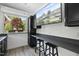 Close-up of the outdoor kitchen space, featuring granite counters, cabinets, a tv, and bar seating at 10825 Rondeau Woods Ct, Raleigh, NC 27614