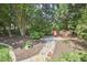 Backyard space with a stone path leading to a seating area with red Adirondack chairs at 109 Hogan Glen Ct, Chapel Hill, NC 27516