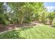 Manicured backyard featuring a verdant lawn, mature trees, and a stone pathway at 109 Hogan Glen Ct, Chapel Hill, NC 27516
