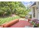 Backyard features a wooden deck with built-in seating, lush greenery, and a well-manicured lawn at 109 Hogan Glen Ct, Chapel Hill, NC 27516
