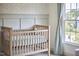 Cozy Bedroom featuring a wooden crib, soft wallpaper, and natural light from a nearby window at 109 Hogan Glen Ct, Chapel Hill, NC 27516