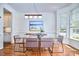 Bright dining room with a glass table, modern chandelier, and beach-themed artwork at 109 Hogan Glen Ct, Chapel Hill, NC 27516