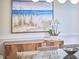 Close-up of a dining room buffet with beach art, orchid, and stylish glass table elements at 109 Hogan Glen Ct, Chapel Hill, NC 27516