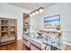 Bright dining room with a glass table, modern lighting, and a view into the kitchen at 109 Hogan Glen Ct, Chapel Hill, NC 27516
