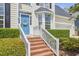 Inviting front entrance with a bright blue door, brick steps and white railings, surrounded by lush green landscaping at 109 Hogan Glen Ct, Chapel Hill, NC 27516