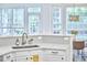 Bright kitchen features a gray tile backsplash, white cabinets, and a stainless steel sink overlooking backyard at 109 Hogan Glen Ct, Chapel Hill, NC 27516