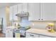 Well lit kitchen featuring stainless steel appliances, white cabinets, and tile backsplash at 109 Hogan Glen Ct, Chapel Hill, NC 27516