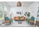 Inviting living room with a tan sofa, green chairs, and large windows for plenty of natural light at 109 Hogan Glen Ct, Chapel Hill, NC 27516