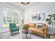 Inviting living room with a tan sofa, green chairs, and large windows for plenty of natural light at 109 Hogan Glen Ct, Chapel Hill, NC 27516